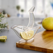 Hand holding the unique bird-shaped manual juicer over a glass.