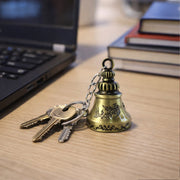 Detailed view of the metal temple bell keychain showcasing its intricate spiritual design.