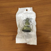 Metal temple bell keychain resting on a textured surface, showcasing its elegant form.